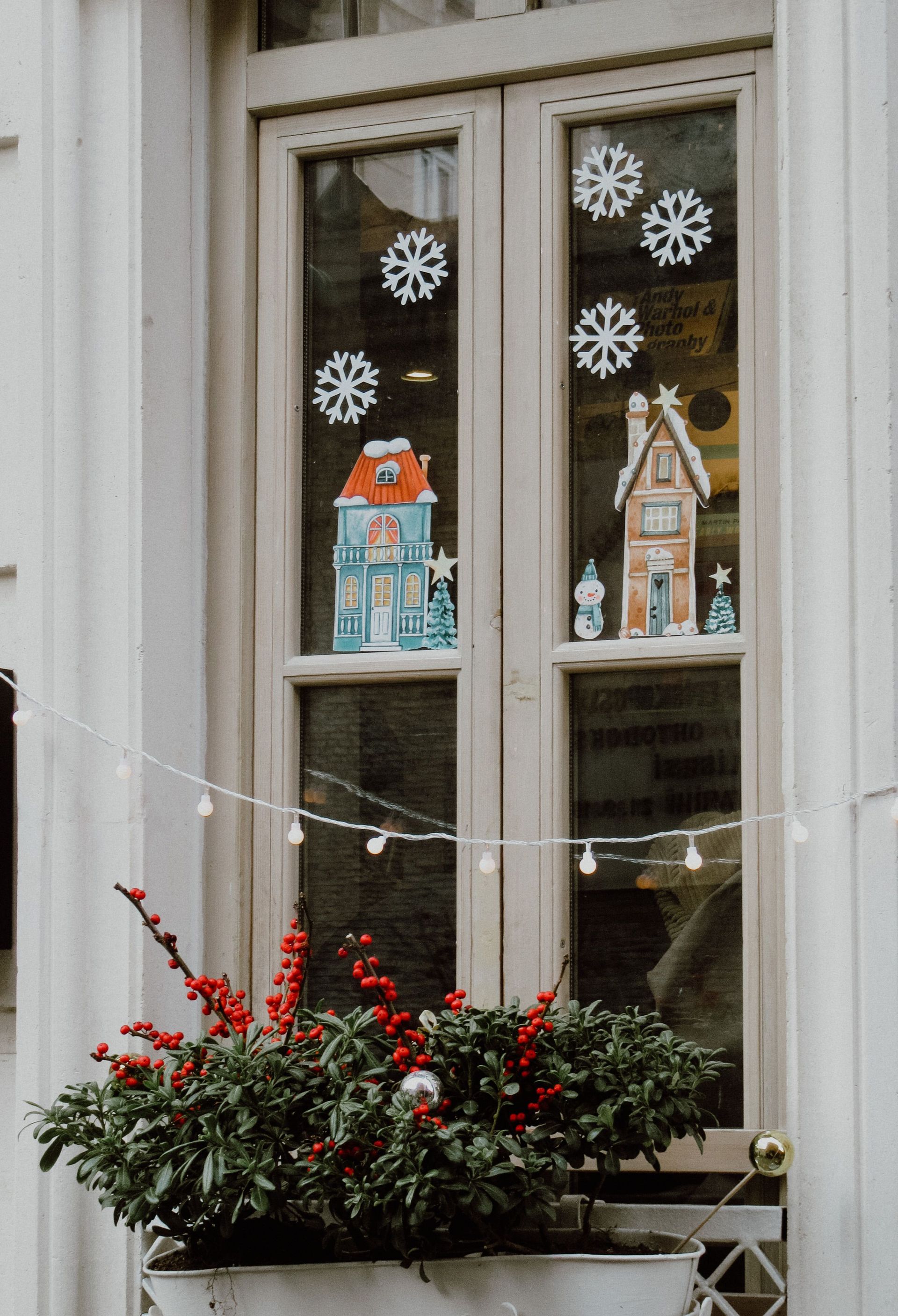 Charming window with Christmas-themed decorations and a festive planter.